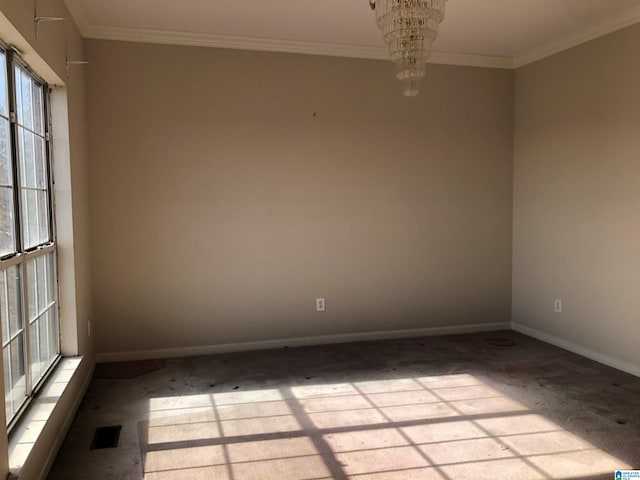 spare room with crown molding and a chandelier