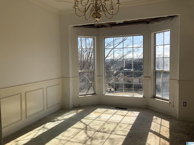 unfurnished dining area featuring ornamental molding and a notable chandelier