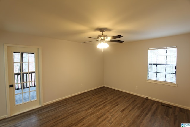 empty room featuring dark wood-type flooring, a wealth of natural light, and ceiling fan