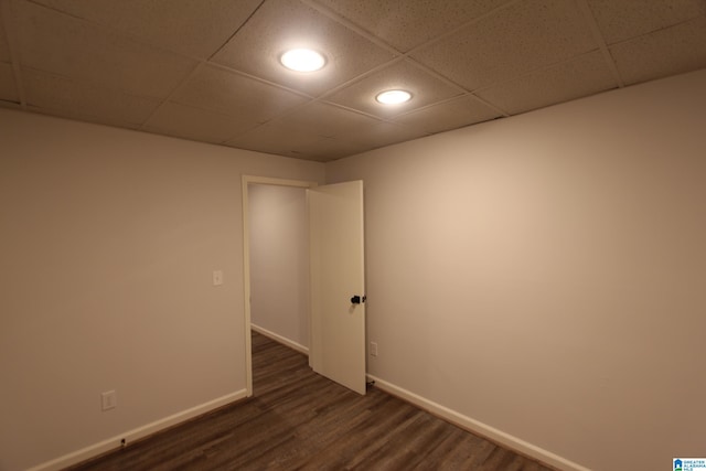 spare room with dark wood-type flooring and a paneled ceiling