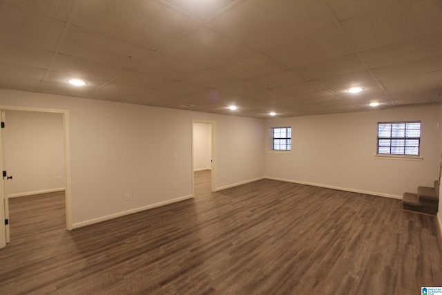 basement with dark hardwood / wood-style floors and a paneled ceiling