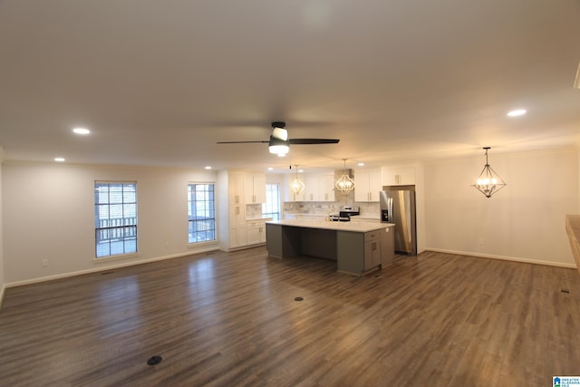 unfurnished living room featuring dark hardwood / wood-style floors and ceiling fan with notable chandelier