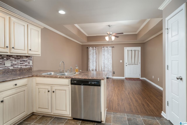 kitchen featuring dishwasher, a peninsula, cream cabinets, a raised ceiling, and a sink