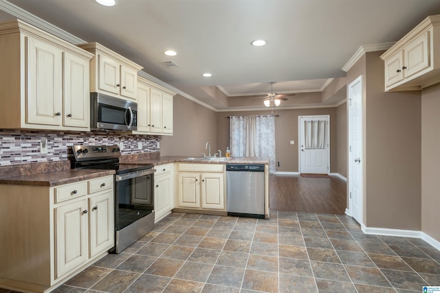 kitchen with visible vents, appliances with stainless steel finishes, cream cabinets, a peninsula, and a sink