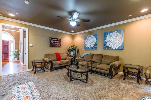 carpeted living room featuring ornamental molding and ceiling fan