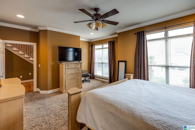 carpeted bedroom with ornamental molding and ceiling fan