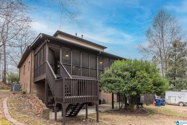 rear view of house with cooling unit and a sunroom