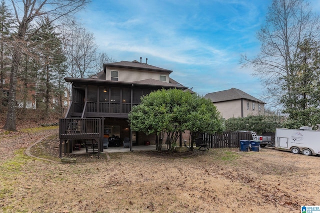 rear view of property with a patio area, a lawn, and a sunroom