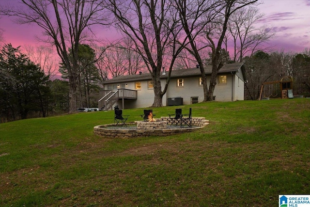 yard at dusk with a fire pit and a deck