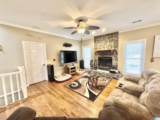 living room with hardwood / wood-style flooring, crown molding, and a textured ceiling