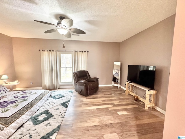 interior space with ceiling fan, light hardwood / wood-style flooring, and a textured ceiling