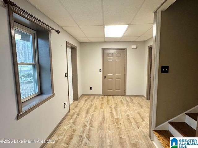 hallway featuring a paneled ceiling and light hardwood / wood-style flooring