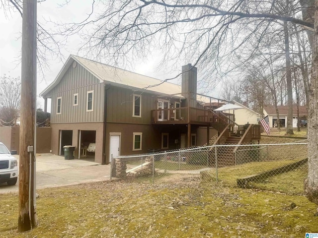 back of house featuring a garage and a deck