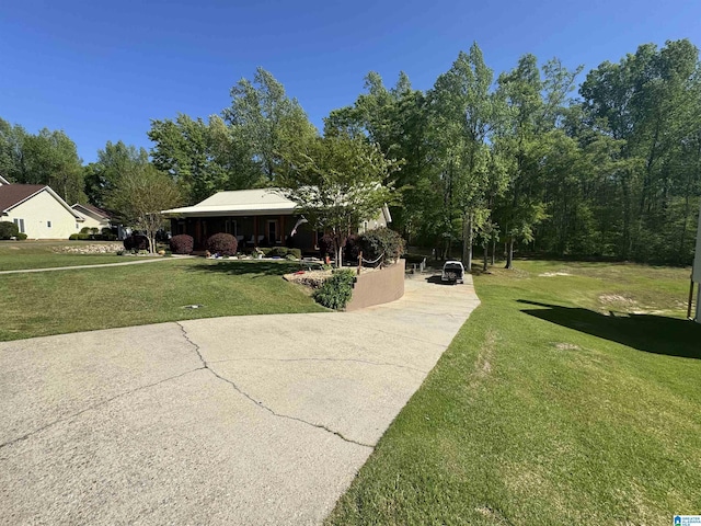 exterior space featuring a front yard and concrete driveway