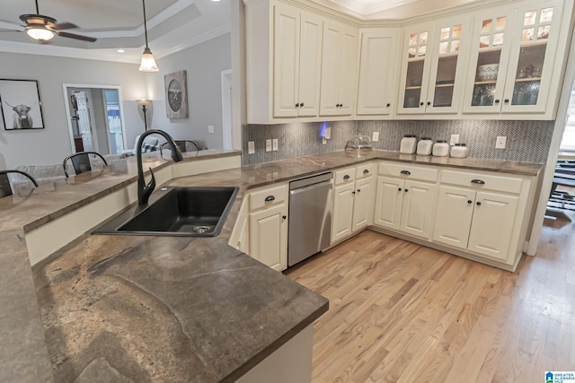 kitchen with a raised ceiling, kitchen peninsula, sink, and dishwasher