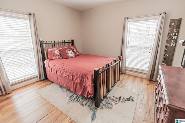 bedroom with multiple windows and light hardwood / wood-style floors