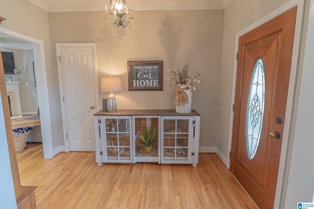 foyer featuring crown molding, an inviting chandelier, and light hardwood / wood-style flooring