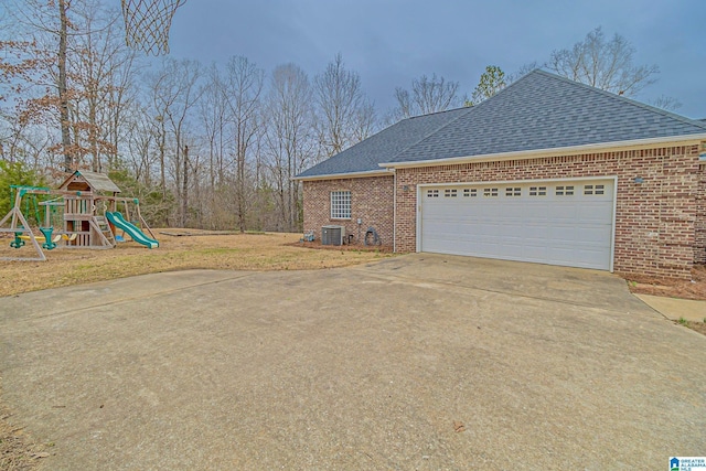 view of side of home featuring a garage and a playground