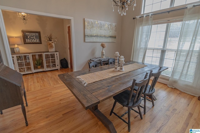 dining space with a healthy amount of sunlight, a notable chandelier, and light wood-type flooring