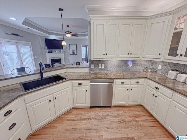 kitchen with white cabinetry, dishwasher, sink, and a raised ceiling