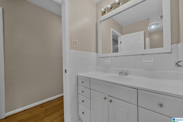 bathroom featuring hardwood / wood-style flooring, vanity, and tile walls