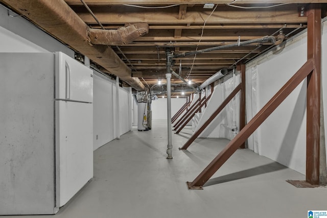 basement featuring white refrigerator and water heater