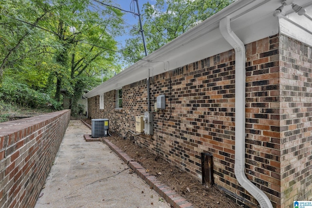 view of side of property with a patio and central air condition unit