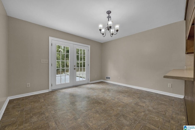 unfurnished dining area featuring french doors and an inviting chandelier