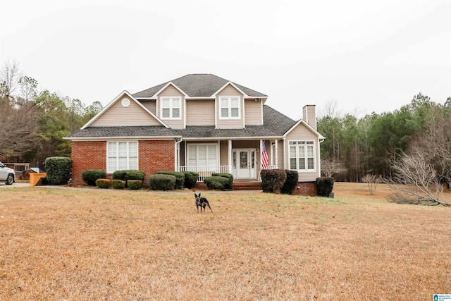 view of front of property featuring covered porch and a front lawn