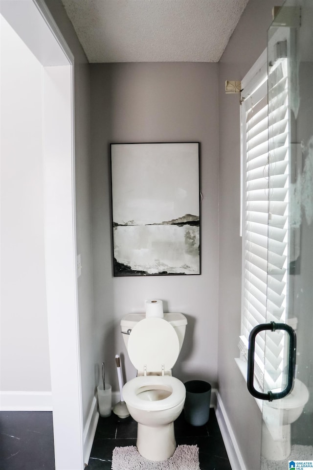 bathroom featuring toilet and a textured ceiling