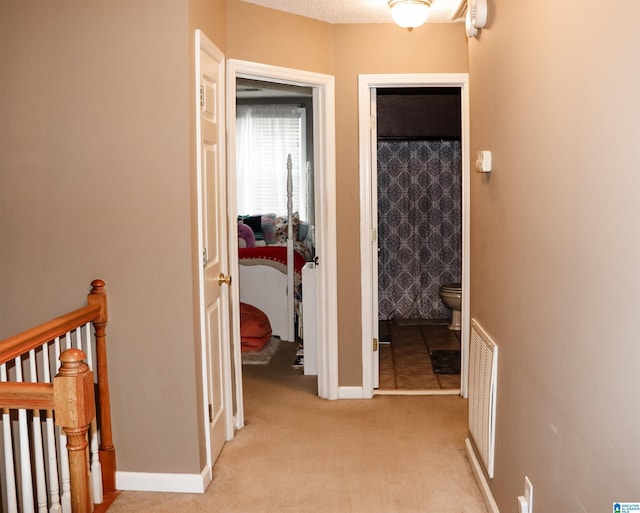 hallway with light colored carpet