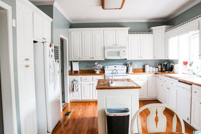 kitchen with white cabinetry, an island with sink, sink, and white appliances