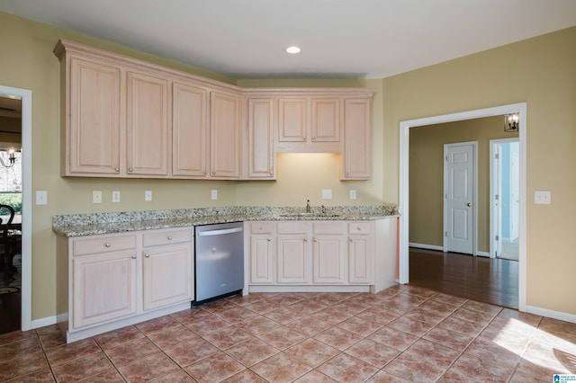 kitchen with sink, stainless steel dishwasher, light tile patterned floors, light stone counters, and an inviting chandelier