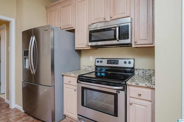 kitchen with light stone counters and appliances with stainless steel finishes