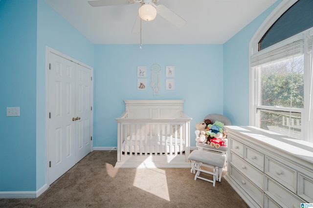 carpeted bedroom with a nursery area and ceiling fan