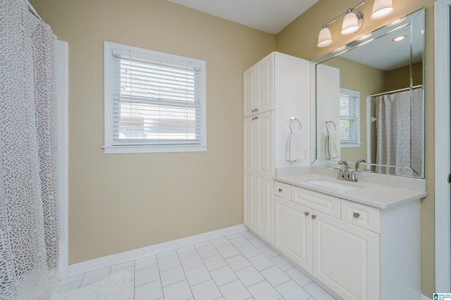 bathroom with a healthy amount of sunlight, tile patterned flooring, and vanity