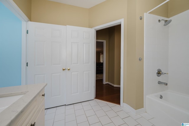 bathroom featuring tile patterned flooring, vanity, and tiled shower / bath