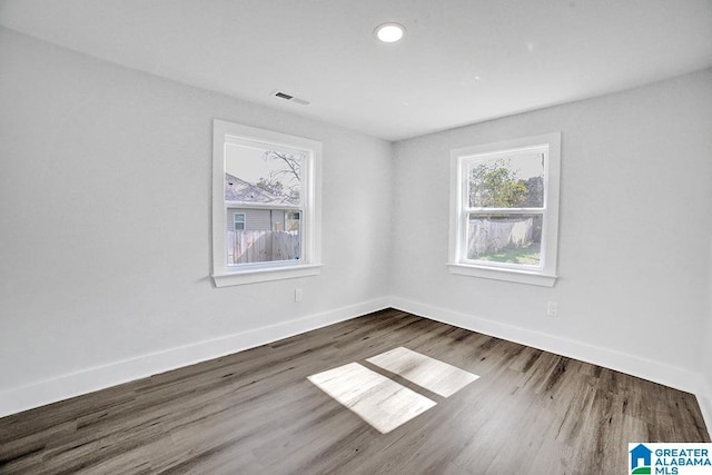 unfurnished room featuring hardwood / wood-style flooring and a healthy amount of sunlight