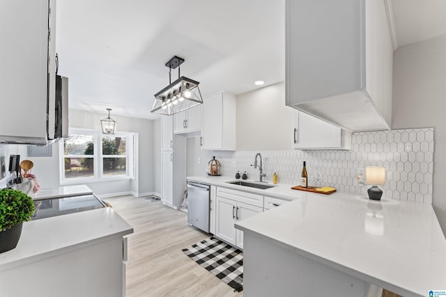 kitchen featuring sink, white cabinetry, decorative light fixtures, dishwasher, and kitchen peninsula