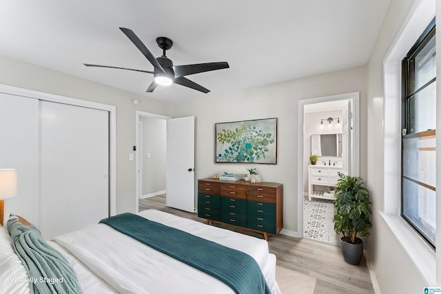 bedroom with ensuite bath, a closet, ceiling fan, and light wood-type flooring