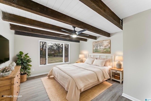 bedroom featuring beamed ceiling, wood-type flooring, and ceiling fan