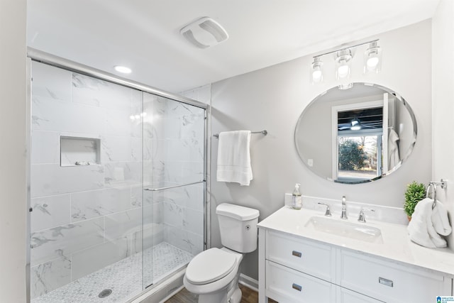 bathroom featuring vanity, a shower with shower door, and toilet