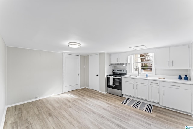 kitchen with sink, white cabinets, light hardwood / wood-style floors, and stainless steel range with electric stovetop