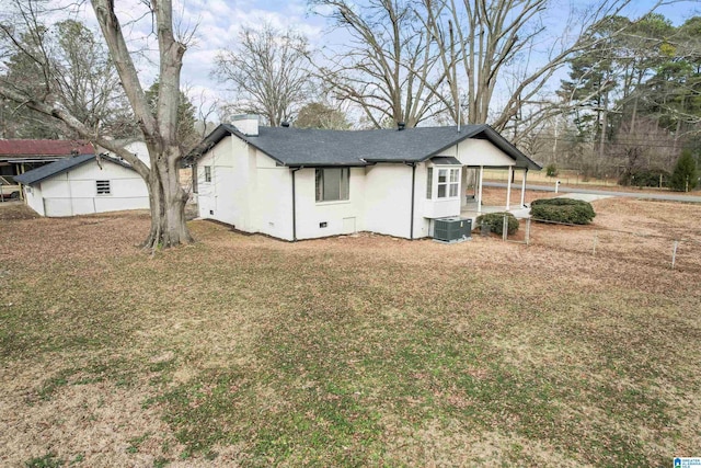 back of property with a lawn and central air condition unit