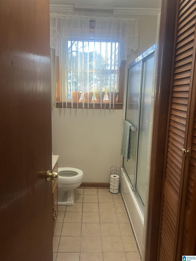 full bathroom featuring toilet, crown molding, vanity, enclosed tub / shower combo, and tile patterned flooring