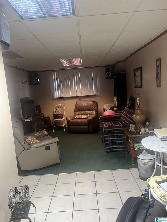 living room with a drop ceiling and light tile patterned floors