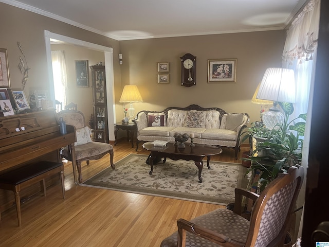 living area with hardwood / wood-style floors and crown molding