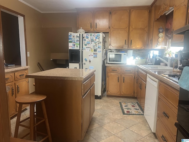 kitchen with a kitchen island, sink, backsplash, crown molding, and white appliances