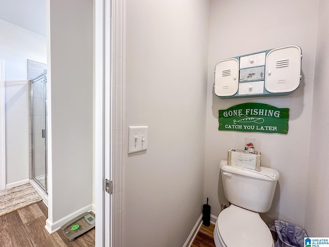 bathroom with an enclosed shower, hardwood / wood-style flooring, and toilet