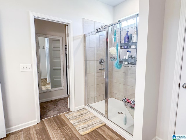 bathroom featuring hardwood / wood-style flooring and walk in shower